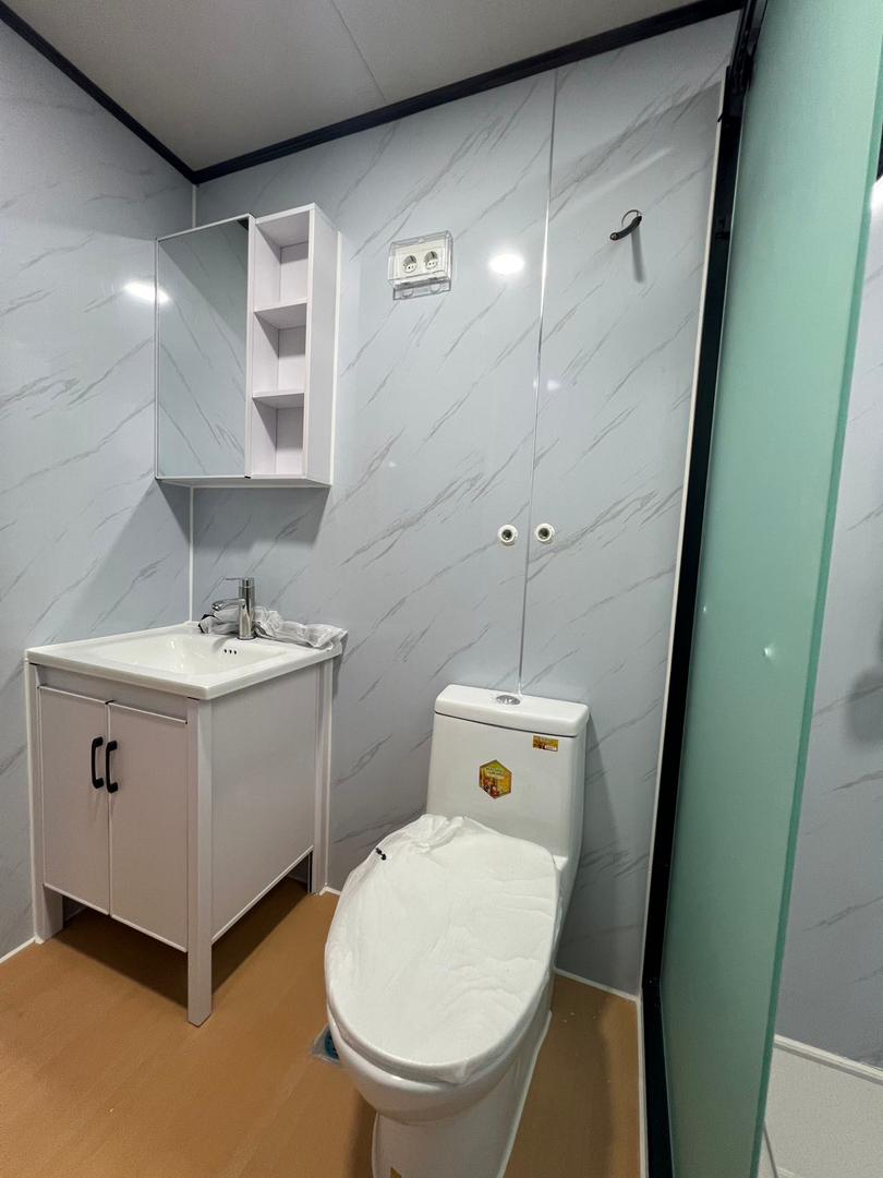 Баня с мраморен ефект, тоалетна, мивка и душ кабина