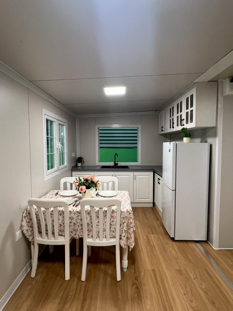 Кухня с трапезария, бели шкафове и хладилник