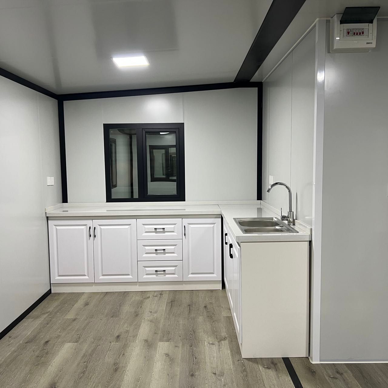 L-образна кухня с мивка и бели шкафове